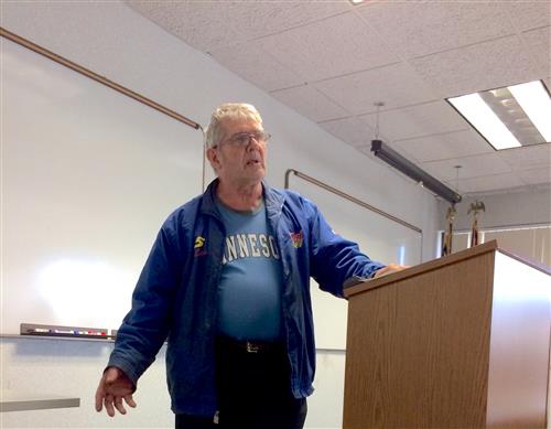 Keith stands at the podium to give his speech. 